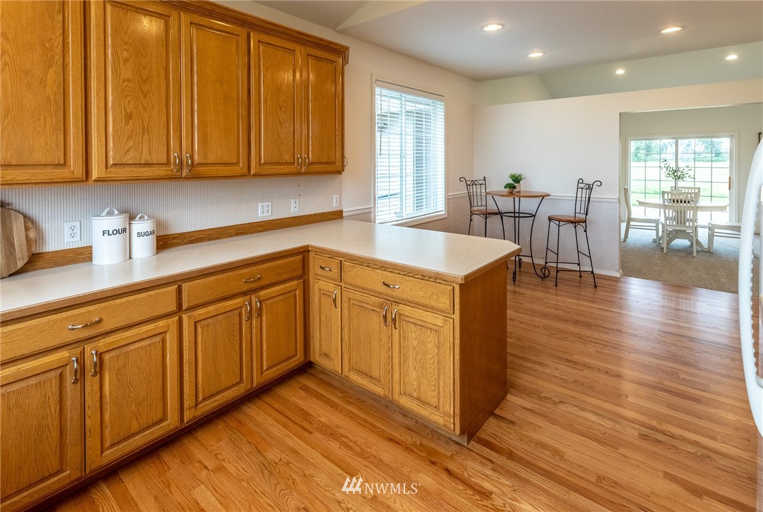 9147 Benson Road Lynden, WA 98264 - Photo 12 of 40 a kitchen with a stove cabinets and wooden floor