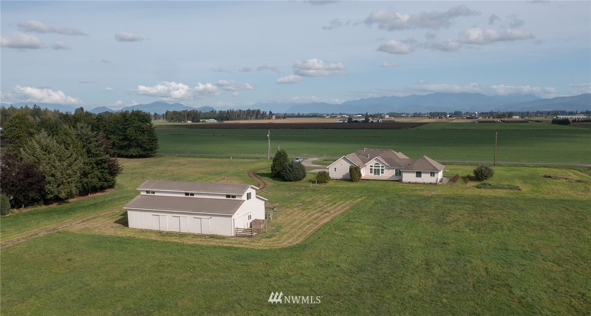 9147 Benson Road Lynden, WA 98264 - Photo 2 of 40 an aerial view of a house with a garden and lake view