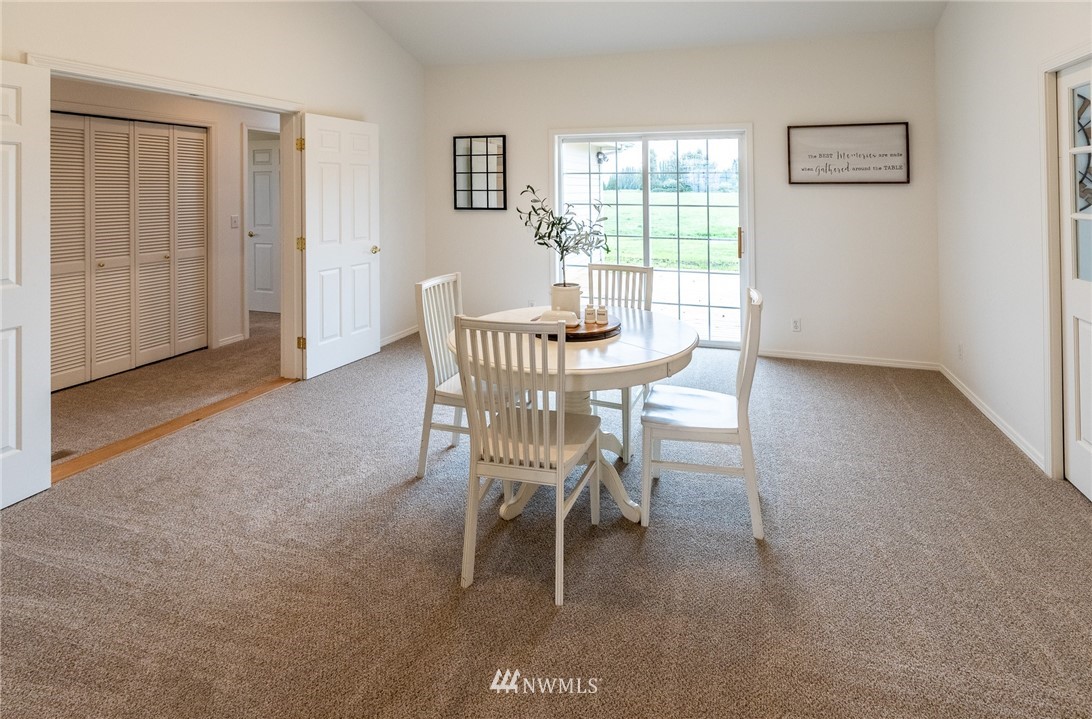 9147 Benson Road Lynden, WA 98264 - Photo 10 of 40 a dining room with wooden floor a chandelier a glass table and chairs