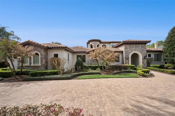 a view of a white house with a yard and large trees