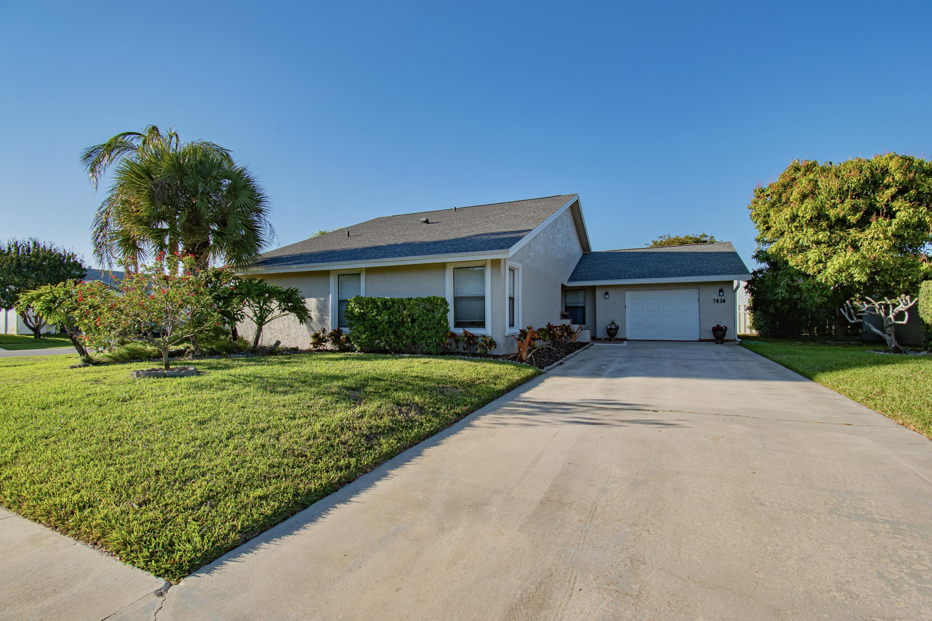 7838 Cypress Crescent Boca Raton, FL 33433 - Photo 2 of 24 a front view of a house with a yard and potted plants