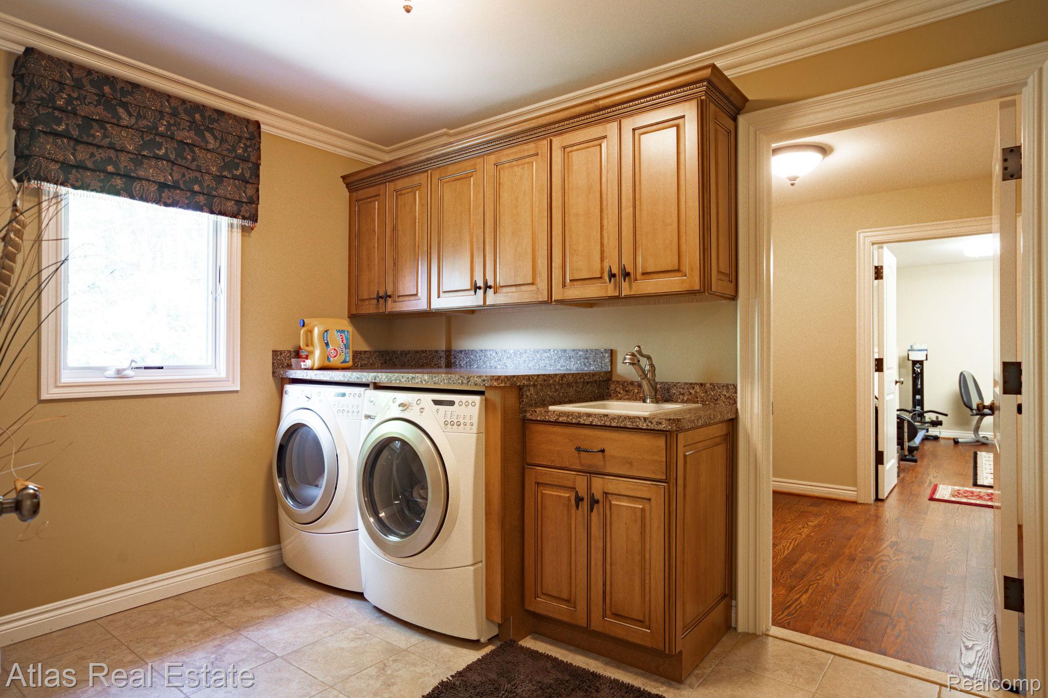 10380 South State Road Goodrich, MI 48438 - Photo 70 of 87 Laundry room featuring wood cabinetry, granite-finish countertops, and a built-in sink