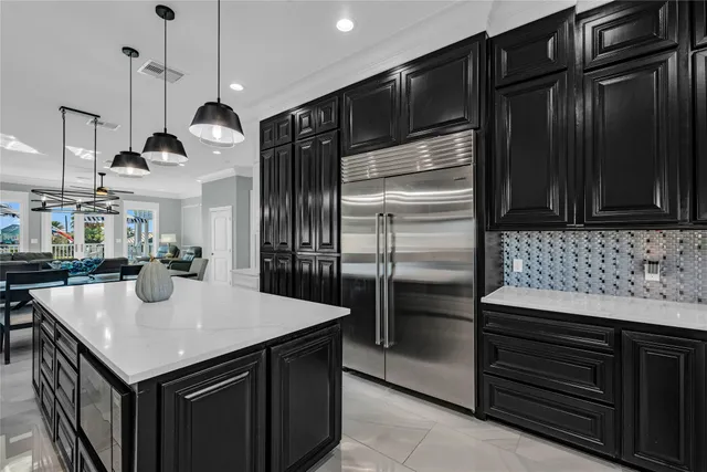 a kitchen with kitchen island a counter space a sink appliances and cabinets