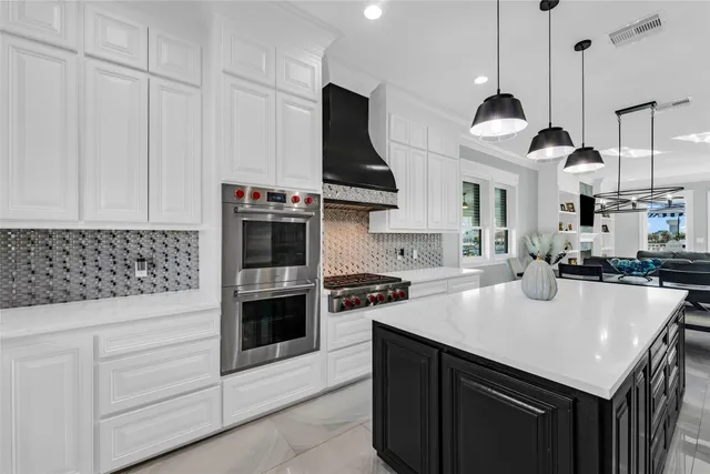 a kitchen with stainless steel appliances granite countertop a sink a stove and a refrigerator