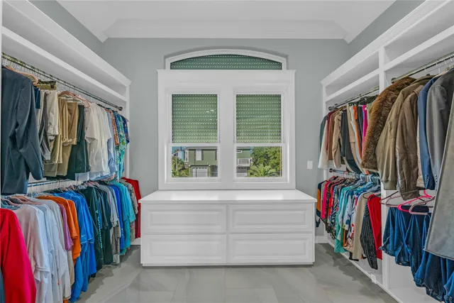 a view of walk in closet with clothes and shoes