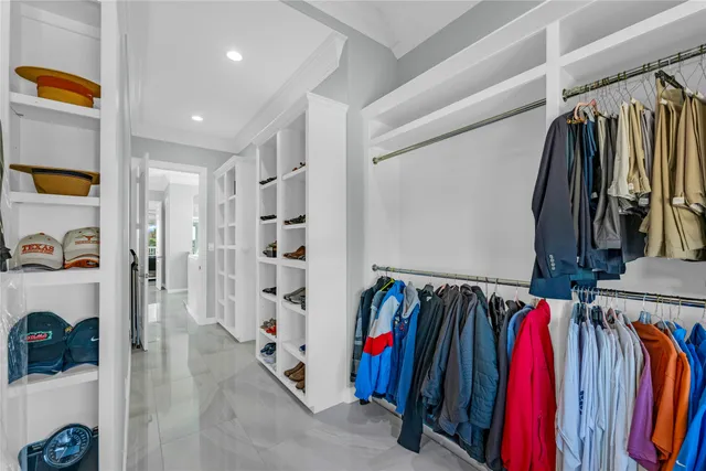 a view of walk in closet with clothes and shoes