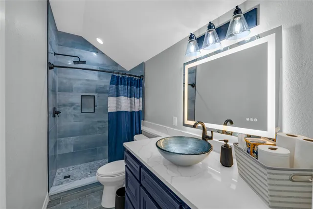 a bathroom with a sink a toilet and shower