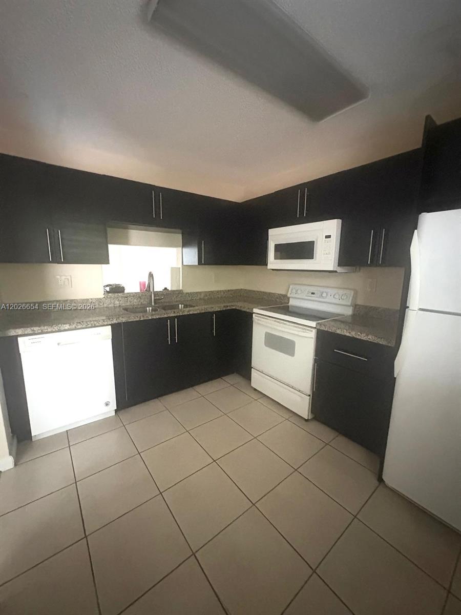 4174 Inverrary Drive, Unit 903 Lauderhill, FL 33319 - Photo 35 of 36 a kitchen with stainless steel appliances granite countertop a sink and a stove