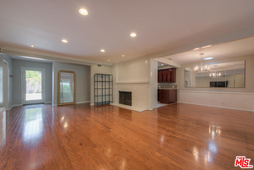 4739 Libbit Avenue Encino, CA 91436 - Photo 5 of 23 a view of an empty room with wooden floor and a kitchen