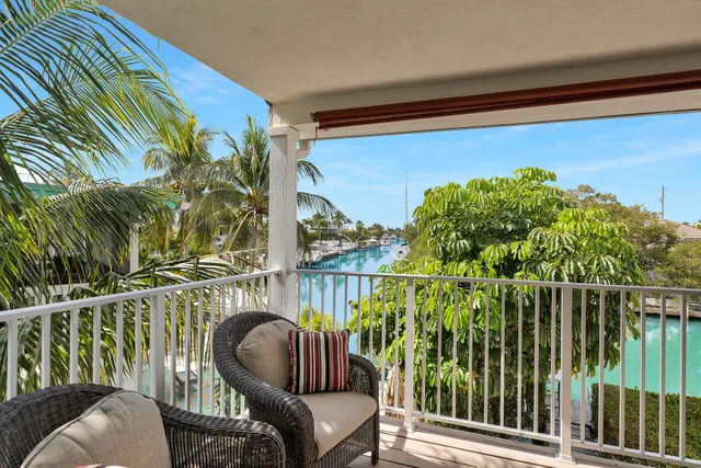 a balcony with wooden floor table and chairs