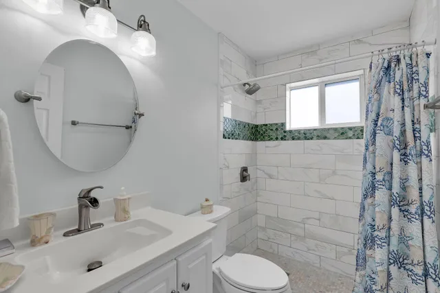 a bedroom with a large bed and a ceiling fan