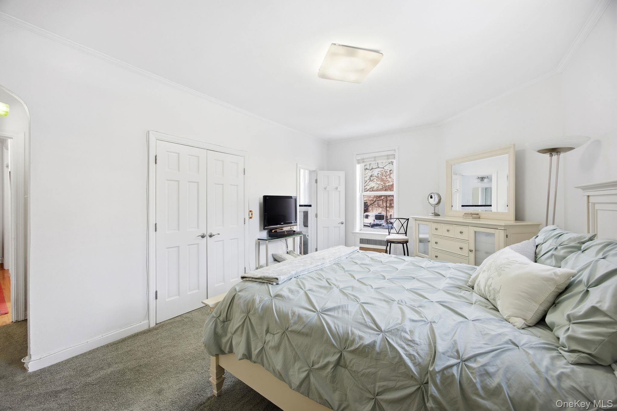 124-16 84th Road, Unit 2E Queens, NY 11415 - Photo 14 of 22 a bedroom with a bed and a television