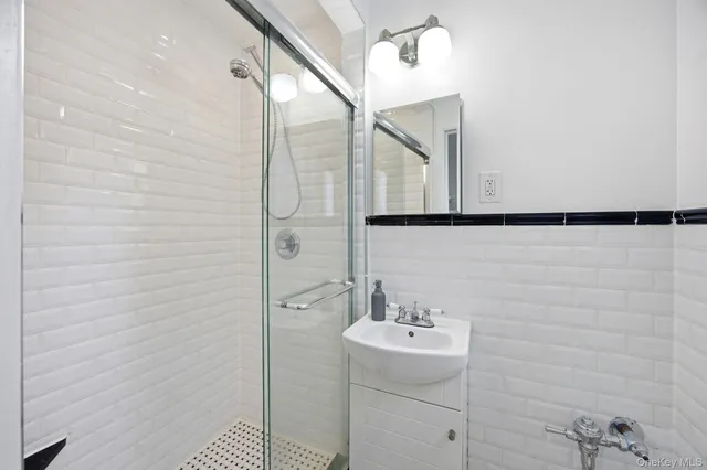 a bathroom with a sink a mirror and shower