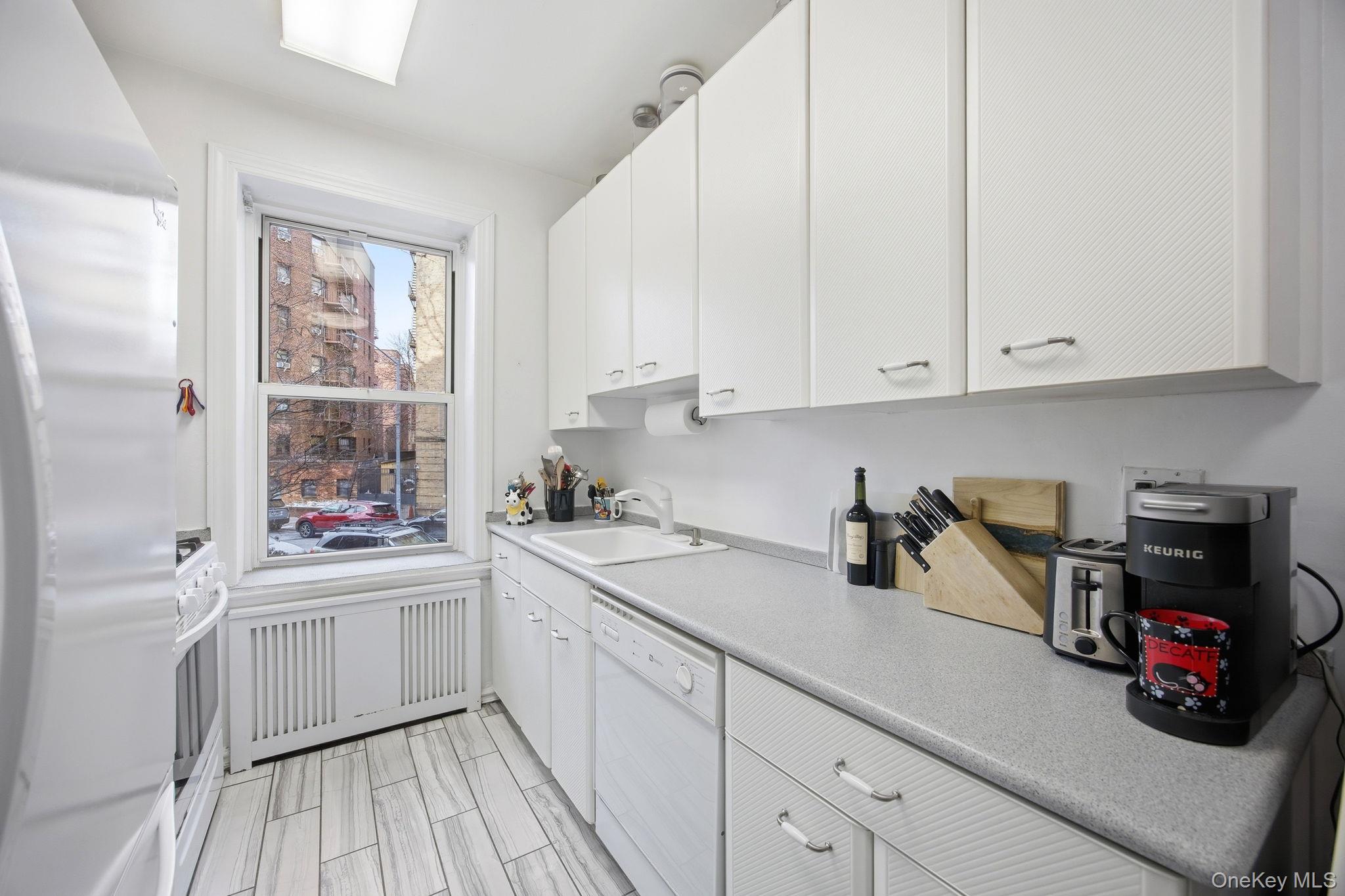 124-16 84th Road, Unit 2E Queens, NY 11415 - Photo 9 of 22 a kitchen with a sink and cabinets