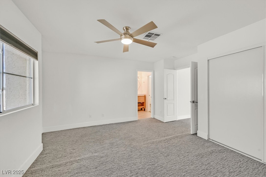 5421 Painted Mirage Road Las Vegas, NV 89149 - Photo 13 of 35 Unfurnished bedroom with baseboards, visible vents, connected bathroom, carpet flooring, and a closet