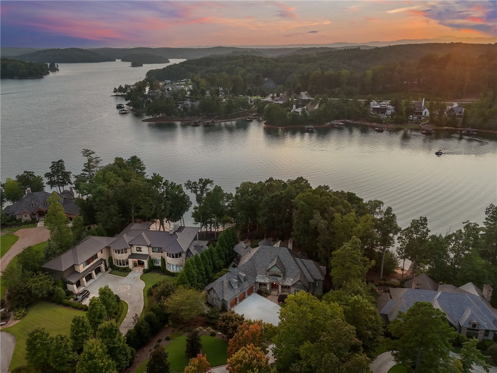 314 Palmer Way Sunset, SC 29685 - Photo 39 of 48 A sprawling lakefront property boasts verdant landscaping and impressive architecture at dusk.