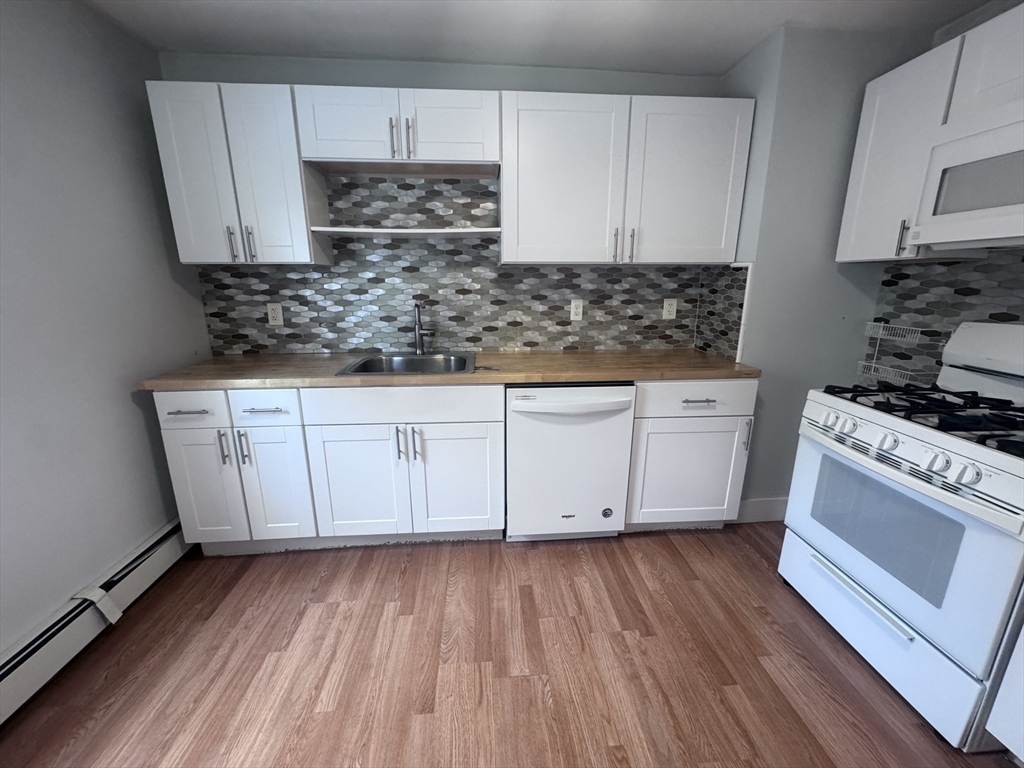 a kitchen with a sink a stove and cabinets