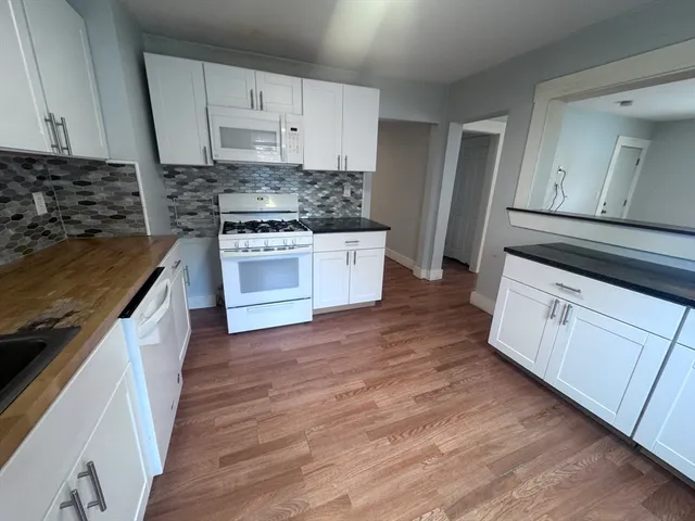 a kitchen with wooden floors and white appliances