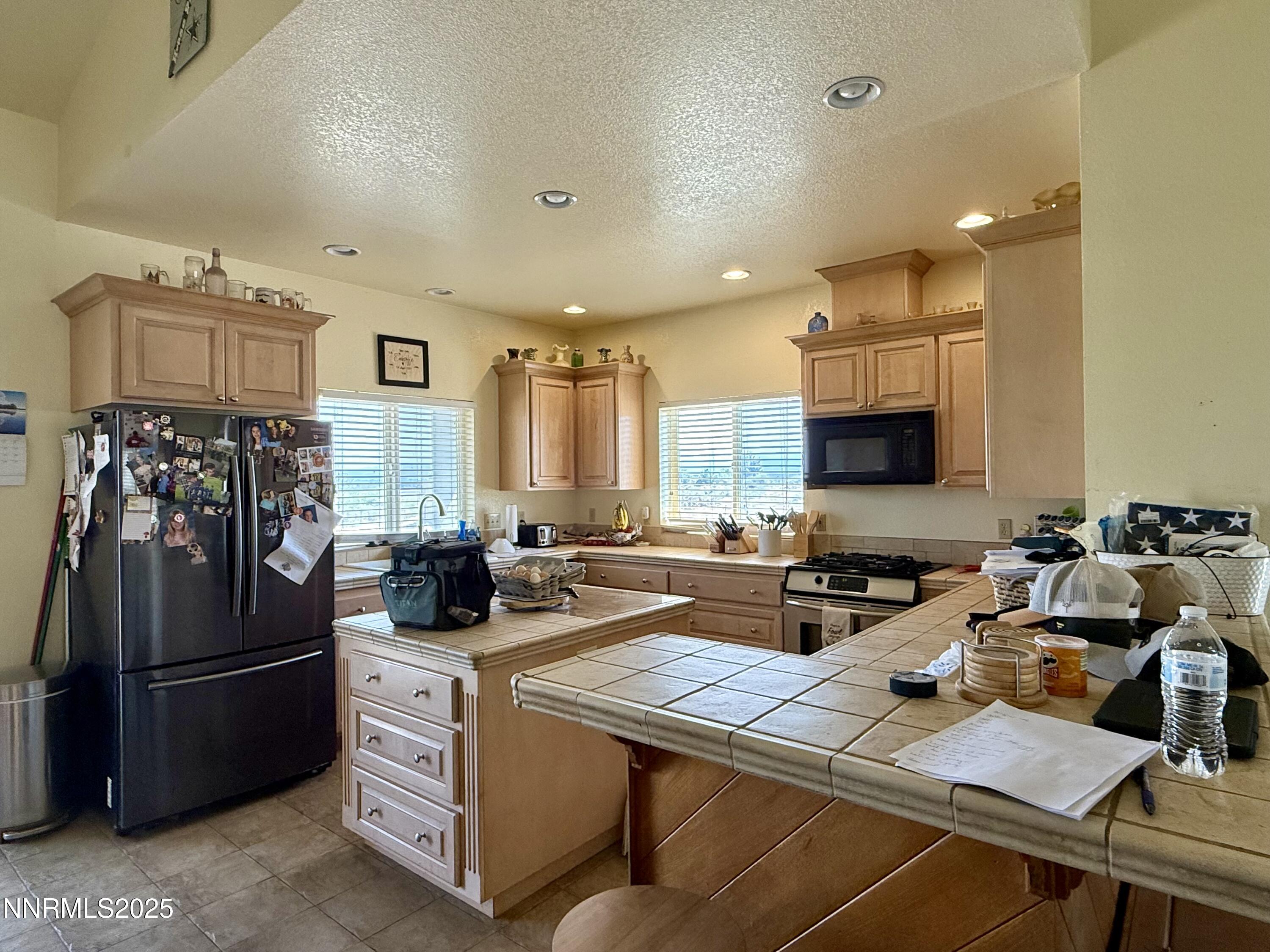52 Upper Colony Road Wellington, NV 89444 - Photo 6 of 21 a kitchen with stainless steel appliances a stove a sink a refrigerator and cabinets