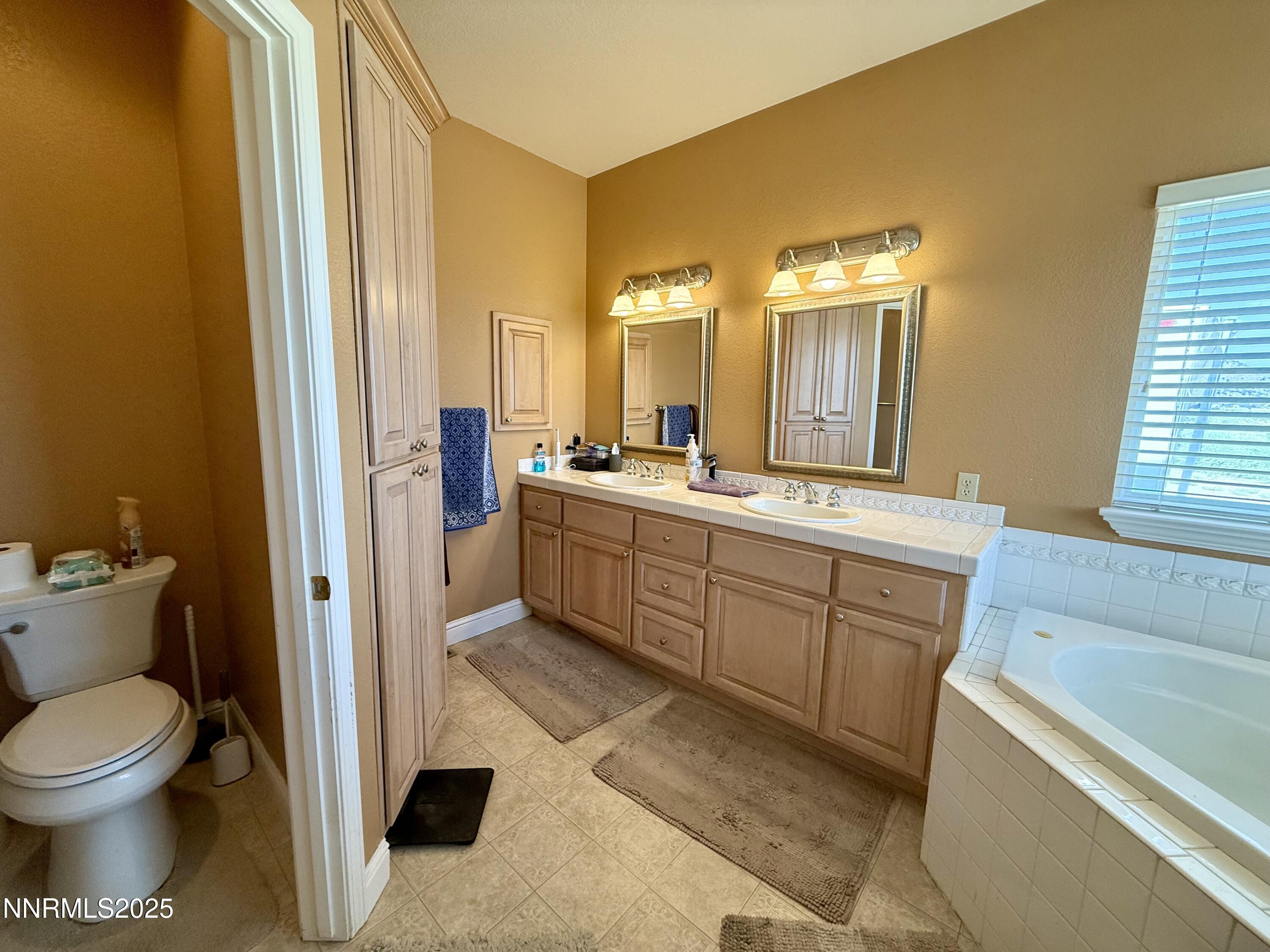 52 Upper Colony Road Wellington, NV 89444 - Photo 9 of 21 a spacious bathroom with a double vanity sink a mirror and a toilet