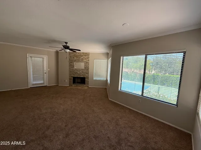 a furnished livingroom with a fireplace and a window