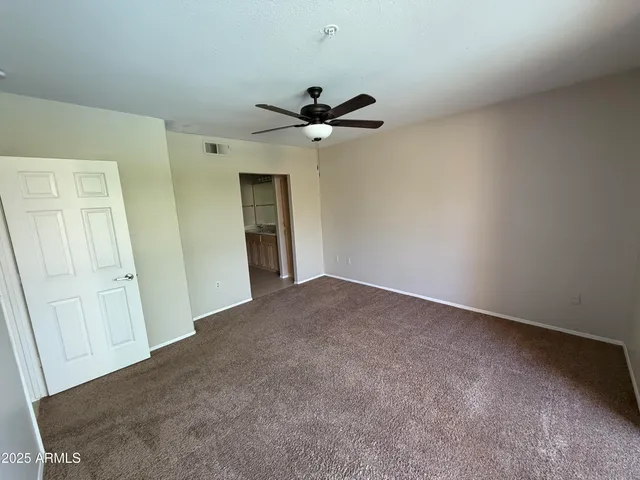 an empty room with a ceiling fan and a window