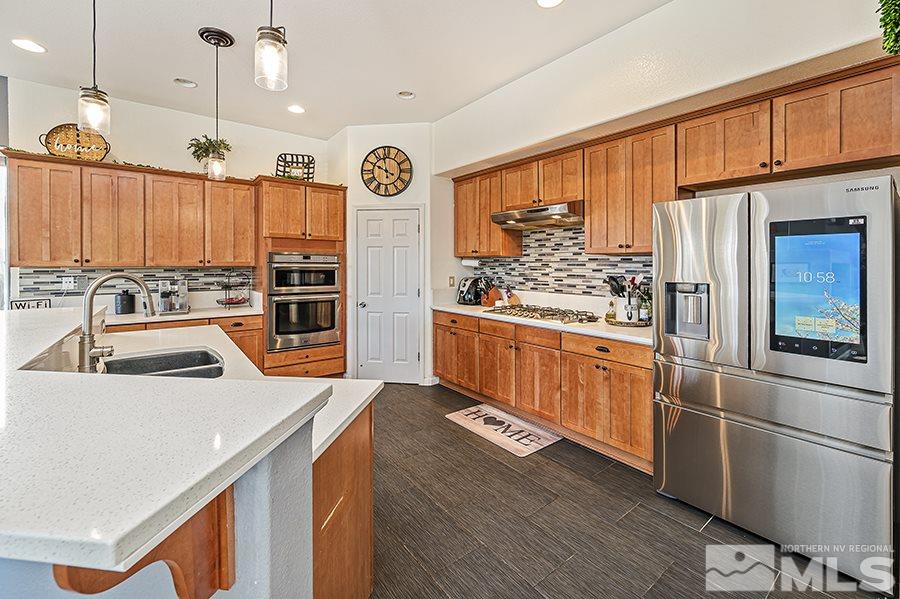 1630 Silver Thread Drive Reno, NV 89521 - Photo 7 of 17 a kitchen with stainless steel appliances a stove a refrigerator and a microwave