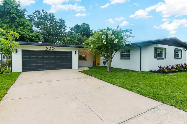 a front view of house with yard and garage