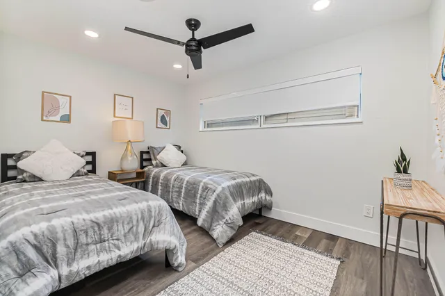 a bedroom with two beds and a desk
