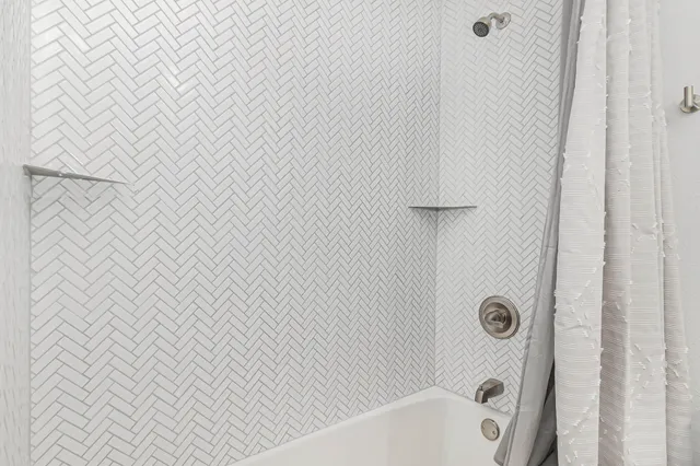 a bathroom with a white bathtub and shower