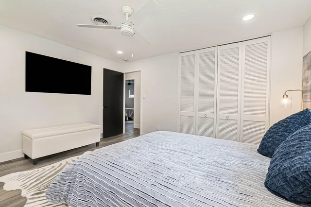 a bedroom with a large bed and a flat screen tv
