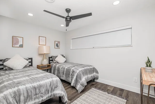 a bedroom with two beds and painting on the wall
