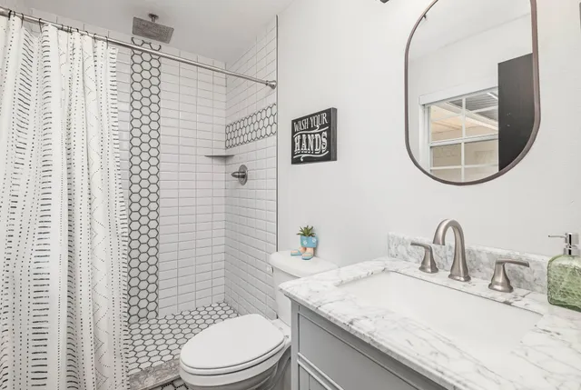 a bathroom with a granite countertop sink and a mirror