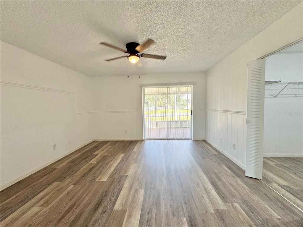 383 Winter Ridge Boulevard, Unit 383 Winter Haven, FL 33881 - Photo 13 of 35 wooden floor in an empty room with a window