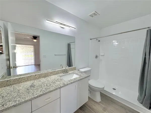 a bathroom with a granite countertop sink toilet and shower