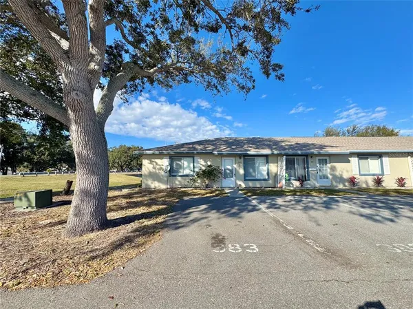a view of a house with a tree next to a yard