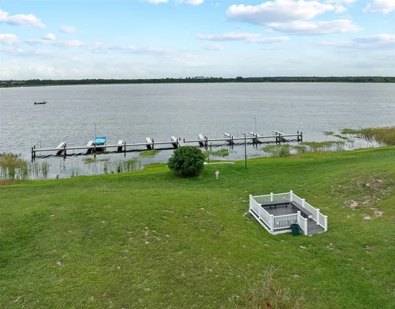 a swimming pool is sitting in the grass near a lake