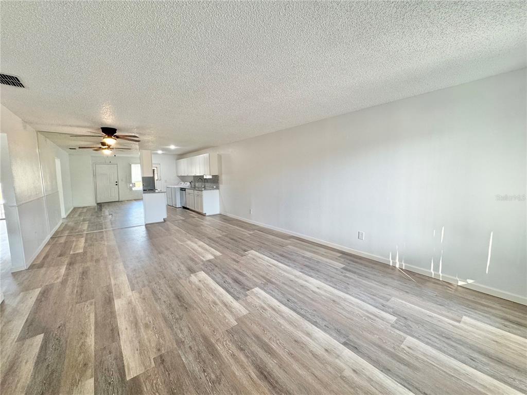 383 Winter Ridge Boulevard, Unit 383 Winter Haven, FL 33881 - Photo 5 of 35 wooden floor in a hall with an empty room