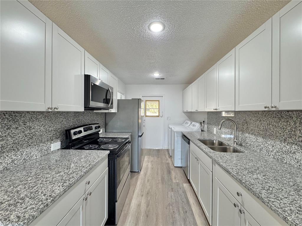 383 Winter Ridge Boulevard, Unit 383 Winter Haven, FL 33881 - Photo 6 of 35 a kitchen with stainless steel appliances granite countertop a sink stove and refrigerator