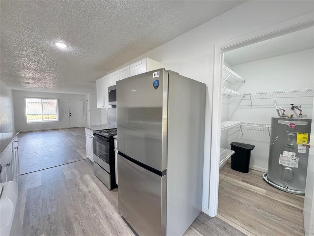 383 Winter Ridge Boulevard, Unit 383 Winter Haven, FL 33881 - Photo 7 of 35 a kitchen with granite countertop a refrigerator and a stove top oven