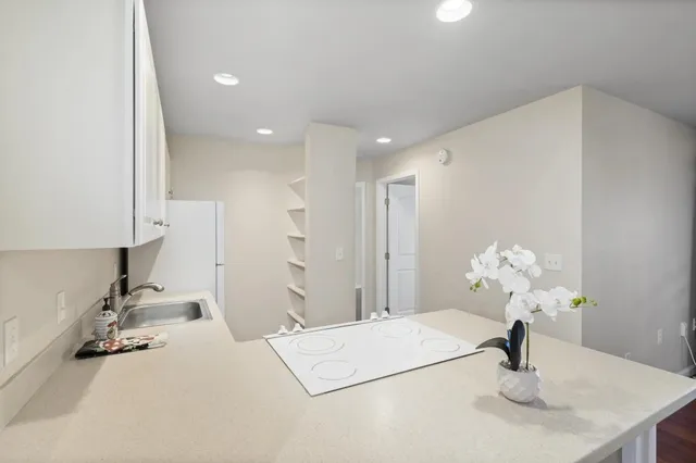 an empty room with wooden floor chandelier fan and windows