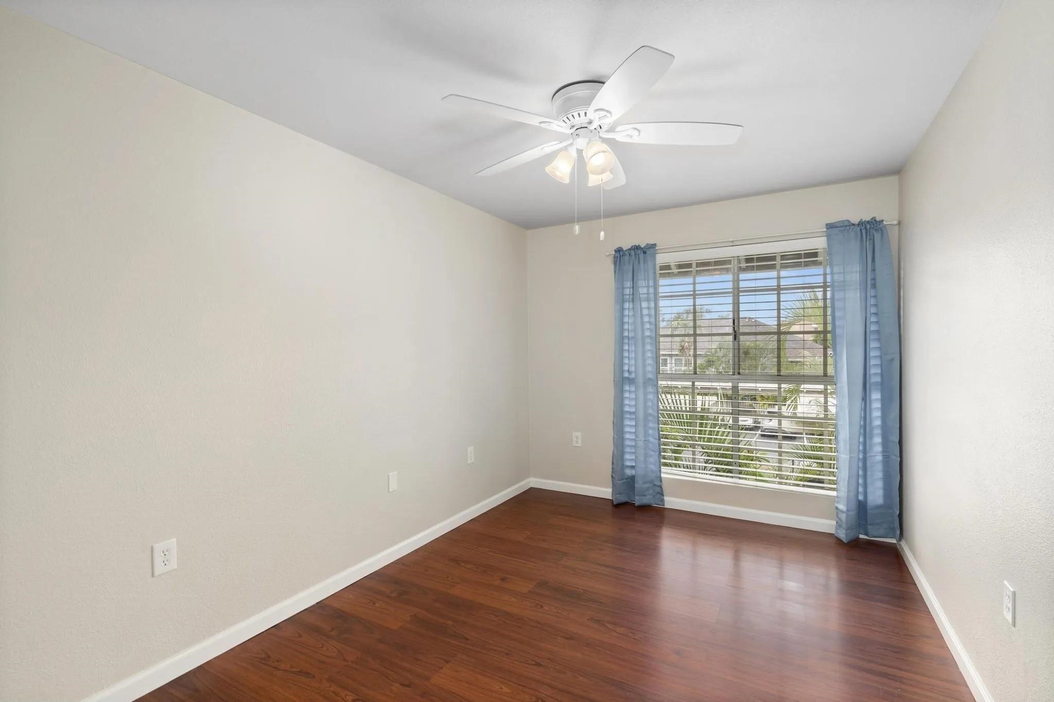 160 Keonekai Road, Unit 14202 Kihei, HI 96753 - Photo 12 of 21 an empty room with wooden floor chandelier fan and windows