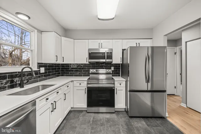a kitchen with stainless steel appliances a refrigerator stove and sink