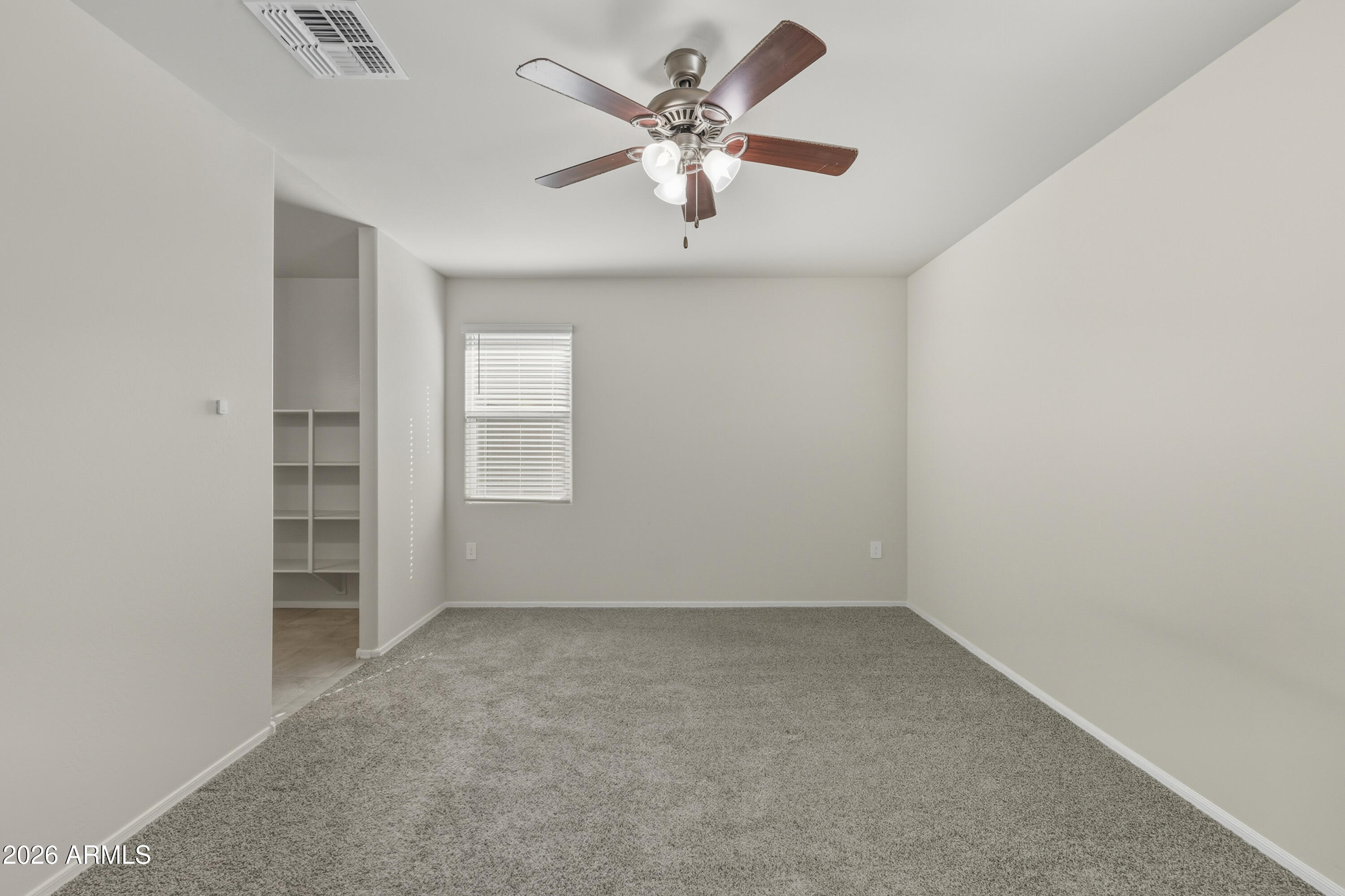 24136 Plow Road Florence, AZ 85132 - Photo 13 of 23 an empty room with a ceiling fan and a window