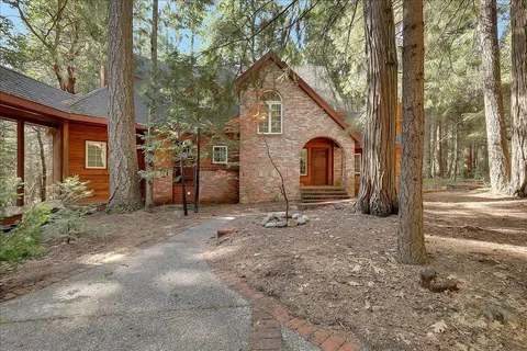 a view of a house with backyard and trees