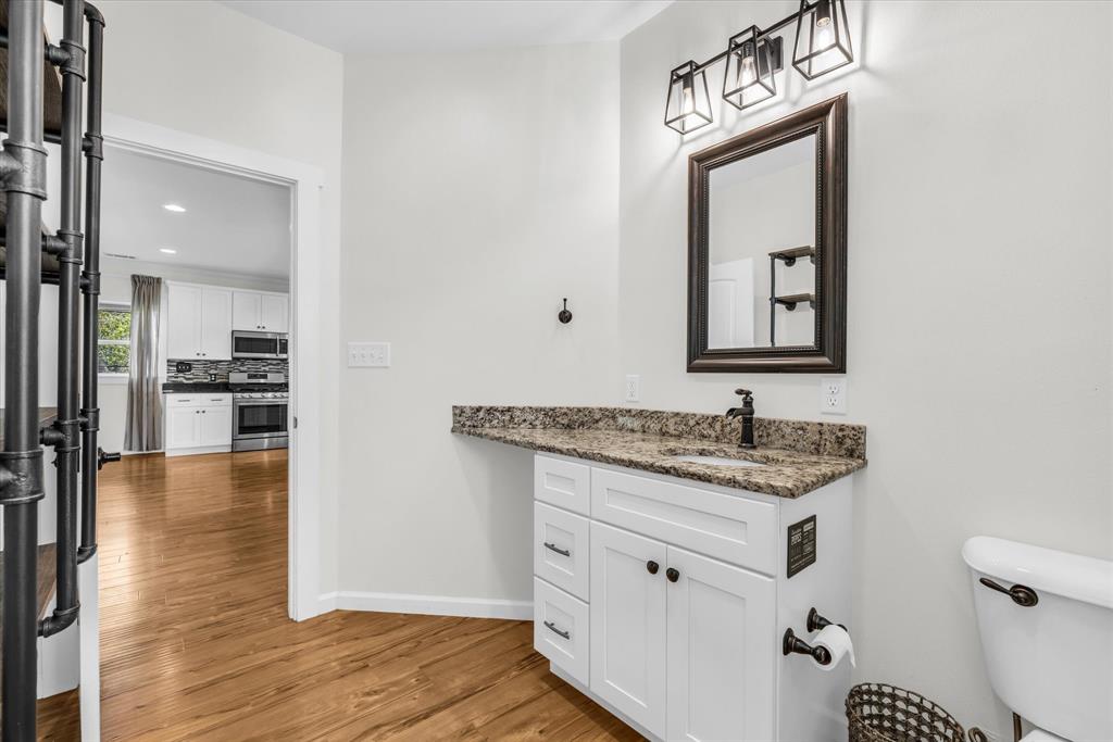 348 Barker Lane Waco, TX 76705 - Photo 9 of 39 a bathroom with a toilet a sink a vanity and mirror