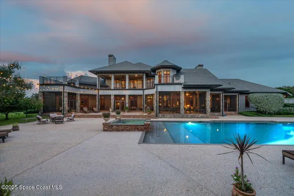 an outdoor view of house with swimming pool and furniture