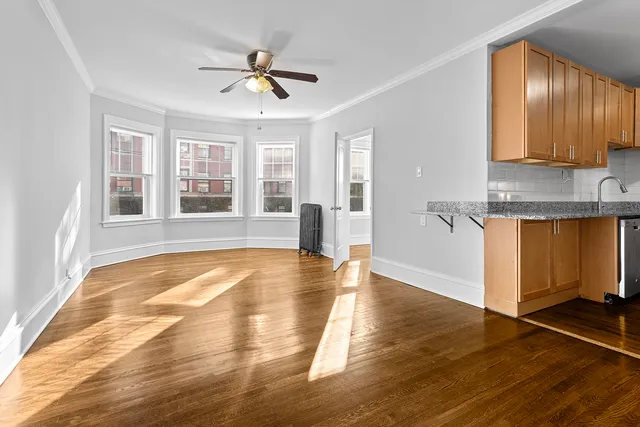 a view of a kitchen with wooden floor and a window
