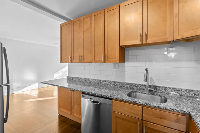 a kitchen with granite countertop a sink and cabinets