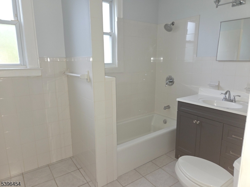 292 Leslie Street, Unit 1R Newark, NJ 07112 - Photo 8 of 9 a bathroom with a sink a toilet and bathtub